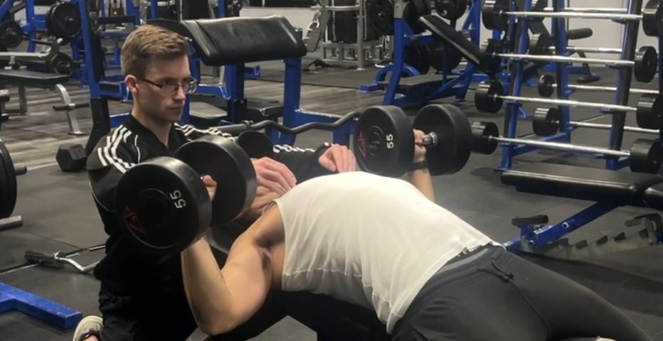 Matt Kennedy personal training bench press with
          client